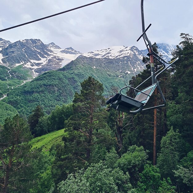 Ein Skilift mit einem Berg im Hintergrund.