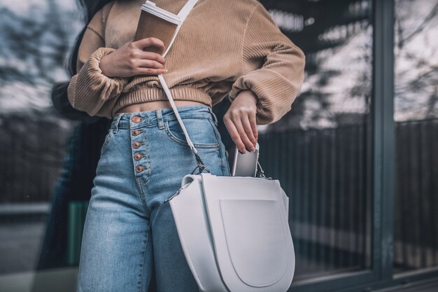 Ein Smartphone verstecken. Schließen Sie herauf Bild einer Frau, die Smartphone zu ihrer Tasche setzt