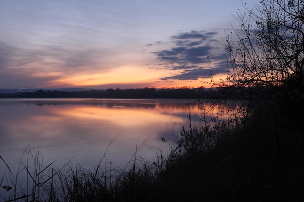 Ein Sonnenuntergang über einem See mit bewölktem Himmel