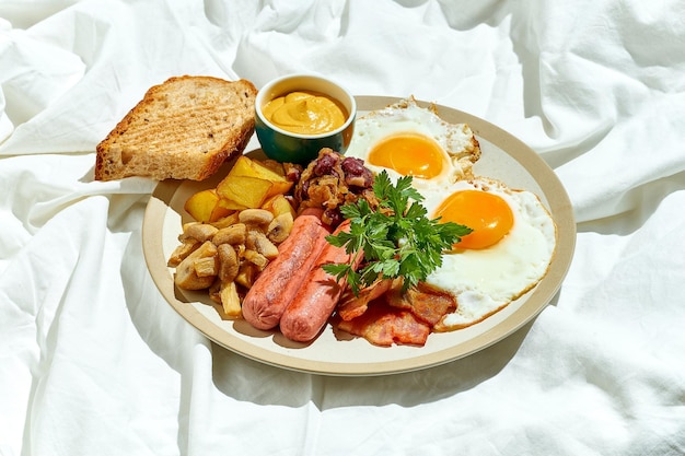 Ein Spiegelei mit Wurst, Bohnen, Speck und Toast in einem Teller auf einem weißen Blatt Englisches Frühstück