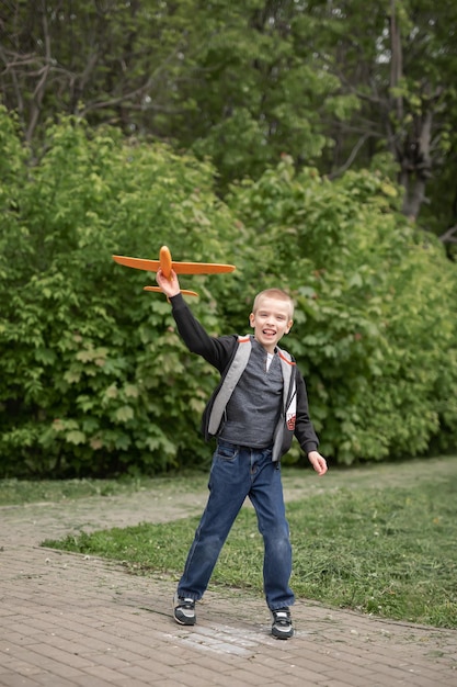 Ein spielender Junge im Park startet ein Flugzeug