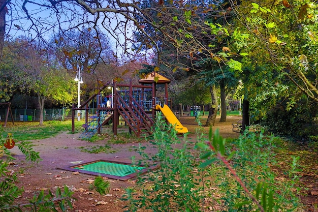 Ein Spielplatz mit Rutsche und Bäumen im Hintergrund.