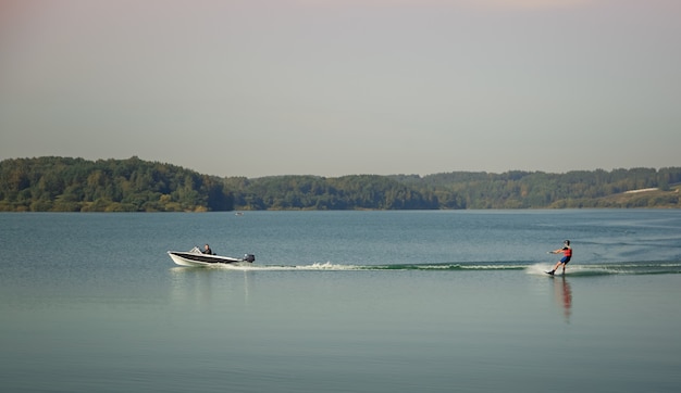 Ein Sportler Wakeboarder fährt hinter einem Boot