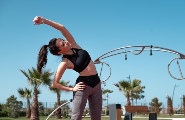 Ein sportliches Mädchen macht im Sommer im Freien Fitness auf einem Sportplatz