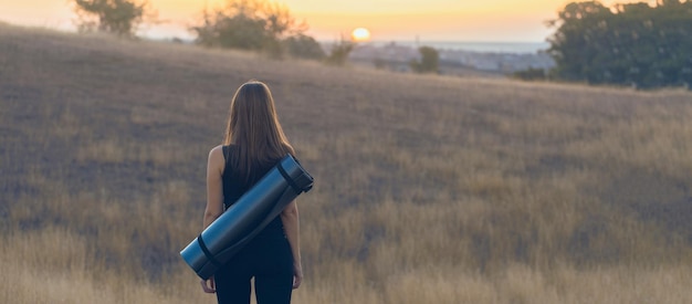 Ein sportliches schlankes Mädchen in Leggings und einem Top, das sich zwischen den Übungen ausruht. Fitness und gesunder Lebensstil.