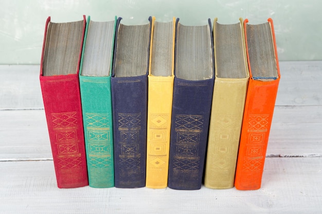 Ein Stapel alter farbiger Bücher im Regal