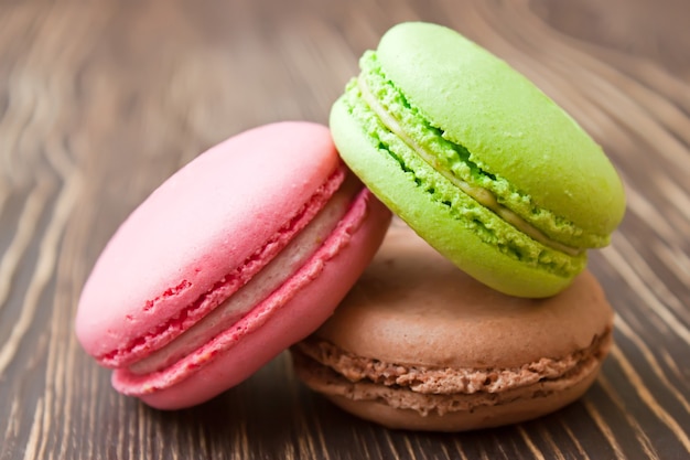 Ein Stapel der bunten traditionellen französischen Dessert-Makarons auf braunem hölzernem Hintergrund.