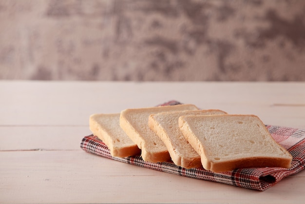 Ein Stapel Toastbrotscheiben auf weißem Holzhintergrund