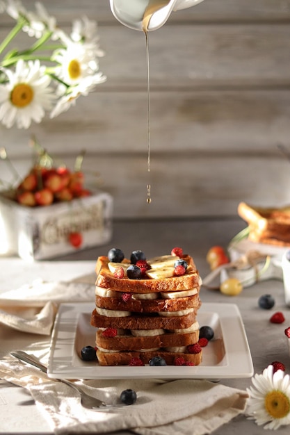 Ein Stapel Waffeln mit Blaubeeren und Zitronen auf einem weißen Teller.