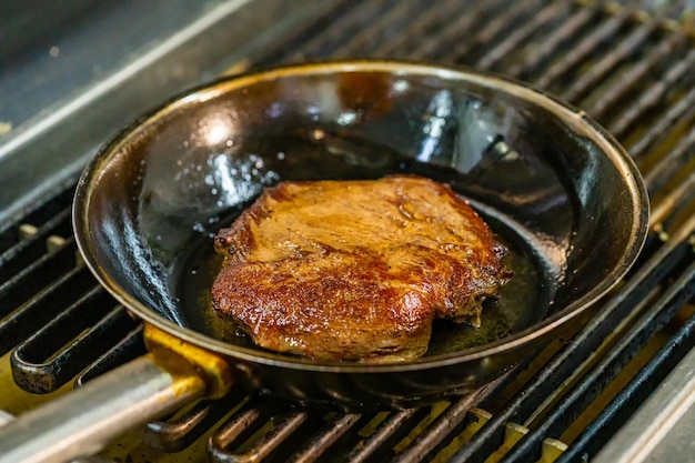 Ein Steak in einer Bratpfanne auf einem Grill
