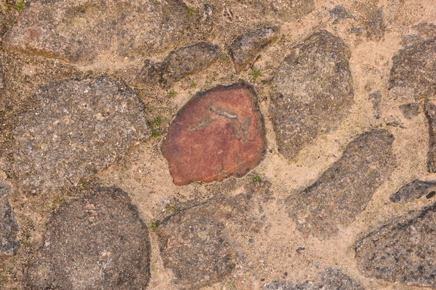 Ein Steinboden mit etwas Sand und Gras