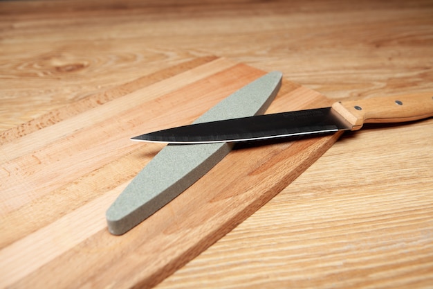 Ein Steinschärfer und ein Messer auf dem Tisch