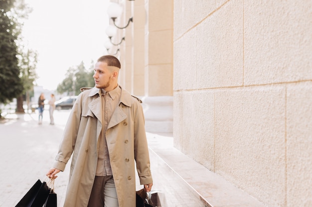 Ein stilvoller junger Mann mit Taschen nach erfolgreichem Einkauf am Black Friday