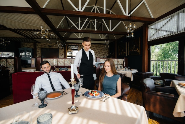 Foto ein stilvoller kellner bedient ein junges paar, das sich in einem gourmetrestaurant verabredet hat. kundenservice in der gastronomie.