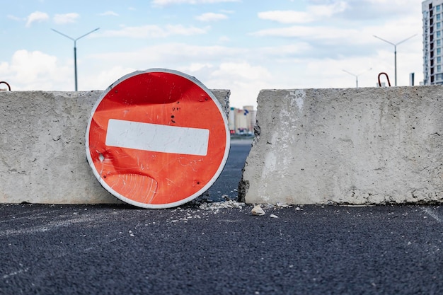 Ein Stoppschild und Betonblöcke blockieren den Eingang zur Baustelle Gesperrte Straße Bau- und Straßenarbeiten