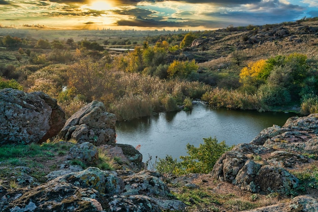 Ein strahlend schöner kleiner Fluss zwischen großen weißen Steinen und grüner Vegetation auf den Hügeln in der Ukraine