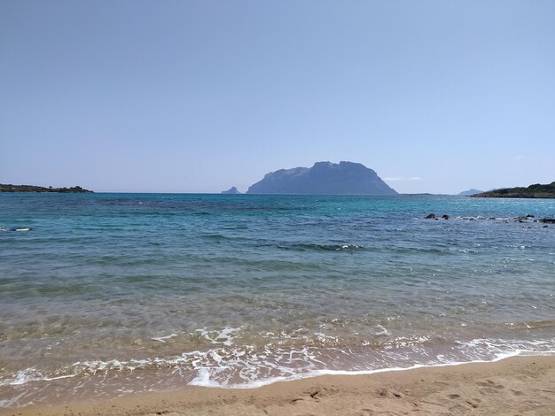 ein Strand mit einem Berg im Hintergrund