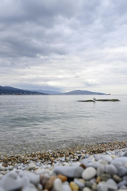 Ein Strand mit einem Boot im Wasser und einem bewölkten Himmel