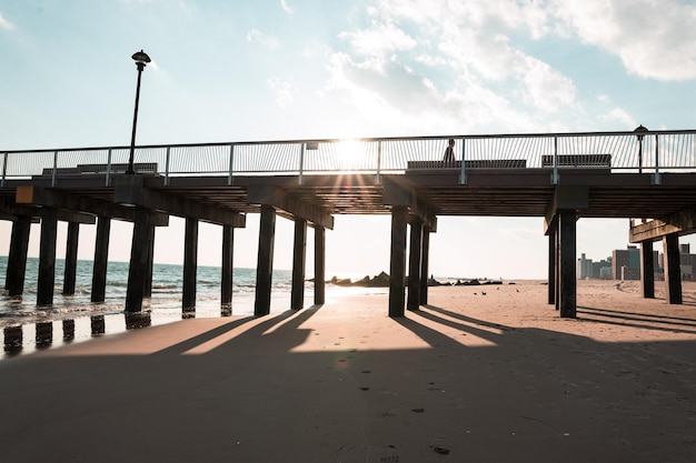 Ein Strand mit einem Pier und die Sonne scheint darauf