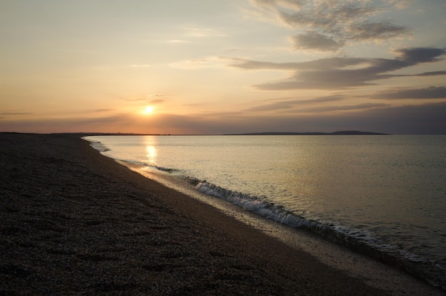 Ein Strand mit einem Sonnenuntergang im Hintergrund