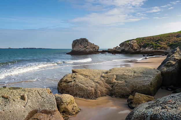 Ein Strand mit Felsen und einem großen Felsen am Ufer