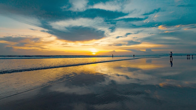 Ein Strand mit Sonnenuntergang und bewölktem Himmel