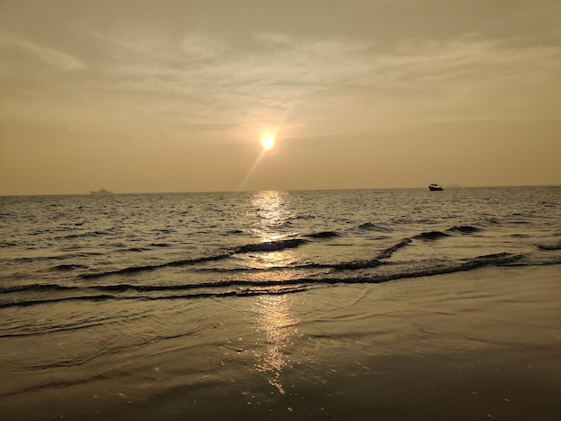 Ein Strand mit Sonnenuntergang und die Sonne geht unter.