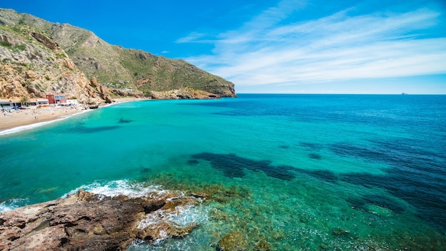 Ein Strand mit türkisfarbenem Wasser und blauem Himmel