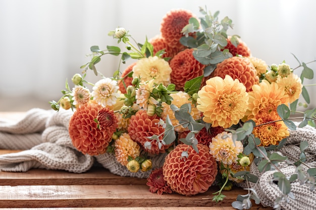 Ein Strauß gelber und orangefarbener Chrysanthemen auf unscharfem Hintergrund.