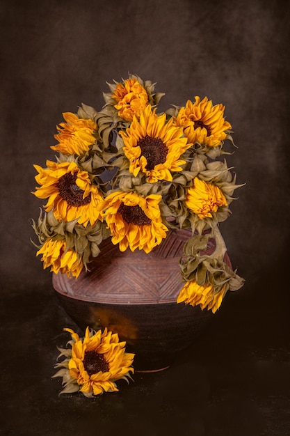 Ein Strauß Herbstsonnenblumen in einer Tonvase