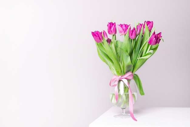 Ein Strauß lila Tulpen in einer Vase Strauß aus Tulpen Blumen in einer Vase Eine Grußkarte
