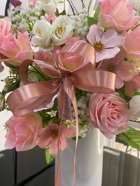 Ein Strauß rosa Rosen mit einem Band mit der Aufschrift „Liebe liegt in der Luft“