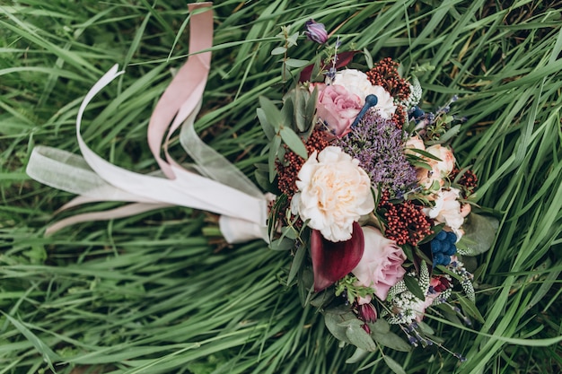 Foto ein strauß roter blumen, schwarzer beeren und gemüse. der brautstrauß