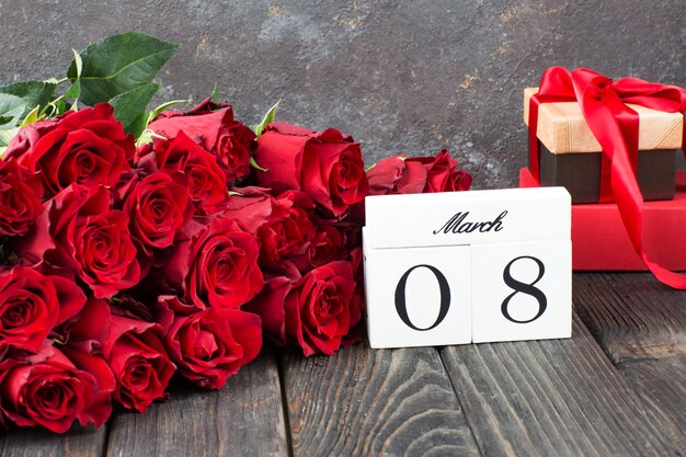 ein Strauß roter Rosen, Geschenke in einer Schachtel und das Datum des 8. März