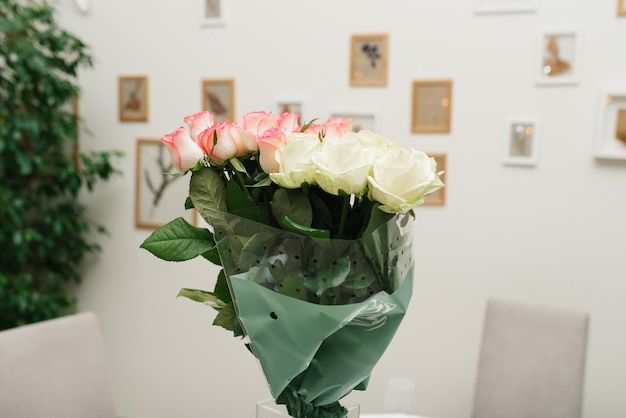 Ein Strauß schöner Blumen in einer Glasvase auf dem Banketttisch.