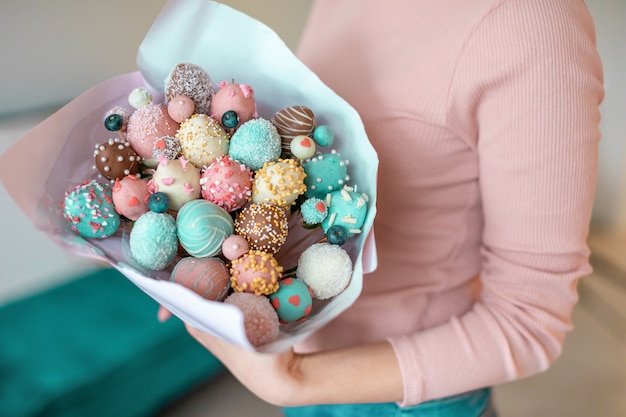 Ein Strauß von Erdbeeren mit Schokoladenüberzug in Frauenhänden