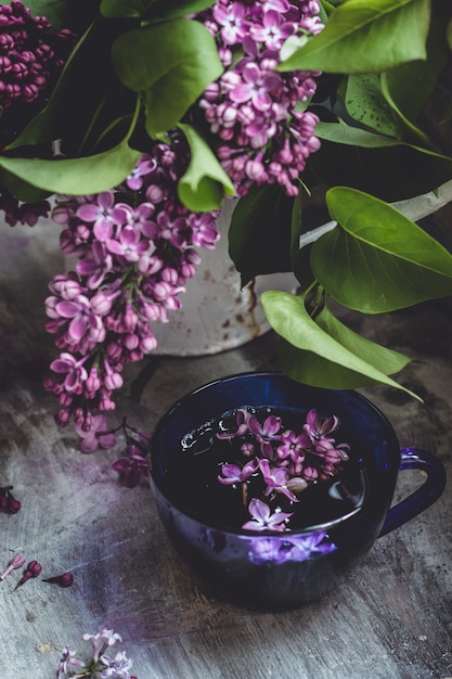 ein Strauß wunderschöner lila rosa Flieder und eine Tasse heißen Tee
