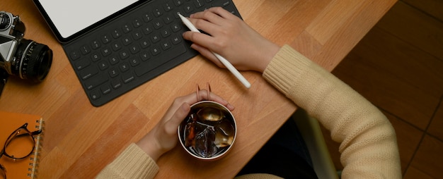 Ein Student, der während einer Aufgabe eine Eiskaffee-Tasse hält