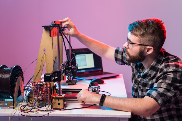 Ein Studentenmann druckt Prototyp auf 3D-Drucker.