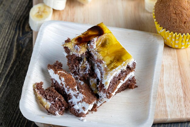 Ein Stück Bananenkuchen und frisch geschnittene Bananen Dessert aus süßer Biskuitbuttercreme mit Bananen und Bananenfüllung