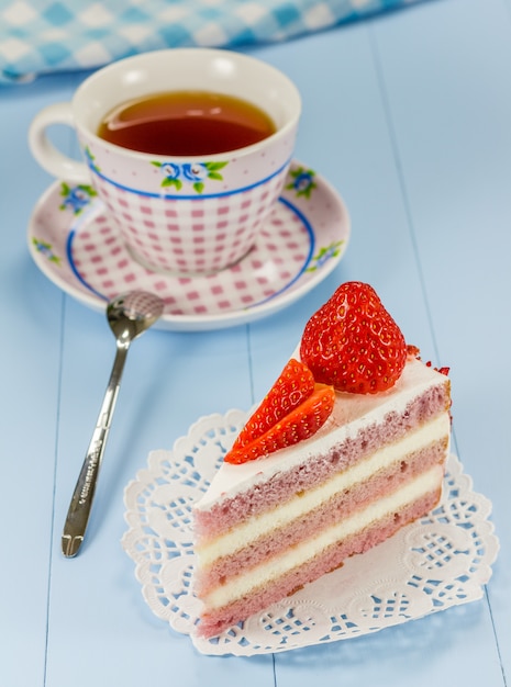 Ein Stück Erdbeerkuchen mit einer Tasse Tee