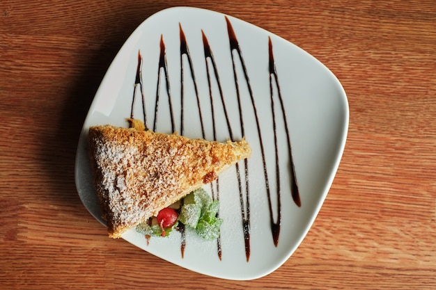 Ein Stück gegossener Honigkuchen mit Schokoladenbelag auf einer Platte, Draufsicht