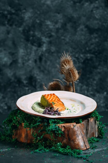 Ein Stück gegrillter Lachs mit weißer Sauce auf einem eleganten Hintergrund