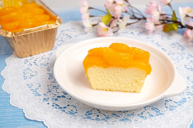 Ein Stück Orangen-Biskuitkuchen mit Orangenscheiben aus frischem Bio-Orangensaft