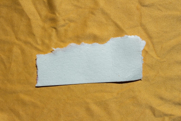 Ein Stück Papier, das von einem gelben Blatt abgerissen wurde.