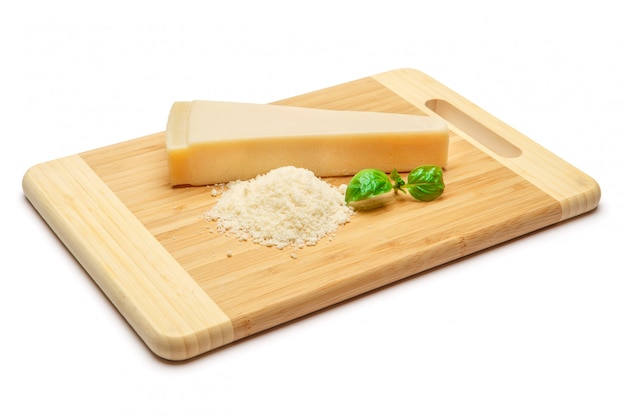 Ein Stück Parmesan und geriebener Käse auf weißem Tisch des Schneidebretts