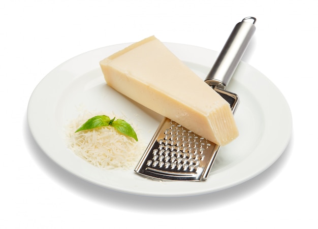 Ein Stück Parmesan und geriebener Käse auf weißem Tisch