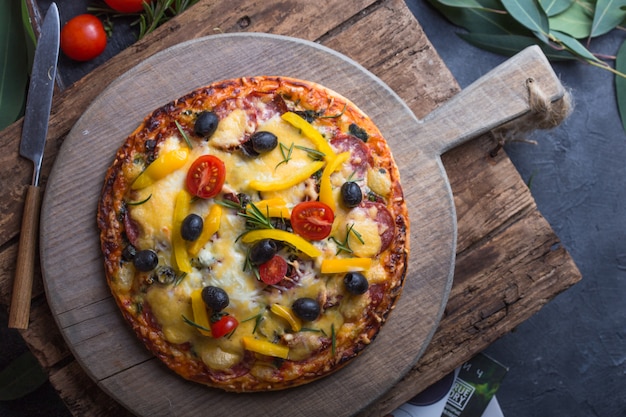 Ein Stück Peperoni-Pizza nehmen. Leckere Peperoni-Pizza auf schwarzem Hintergrund, Nahaufnahmeansicht. Hand Pizza nehmen