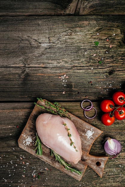 Ein Stück Putenfilet auf einem Schneidebrett aus Holz, Zutaten kochen. vertikales Bild. Ansicht von oben. Platz für Text