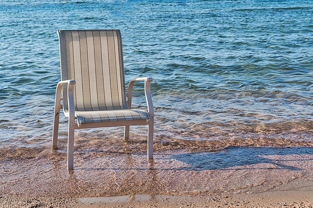 Foto ein stuhl stand im meerwasser nahe der küste